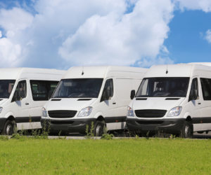 number of new white minibuses and vans outside