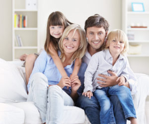 A happy family with children on a white sofa at home